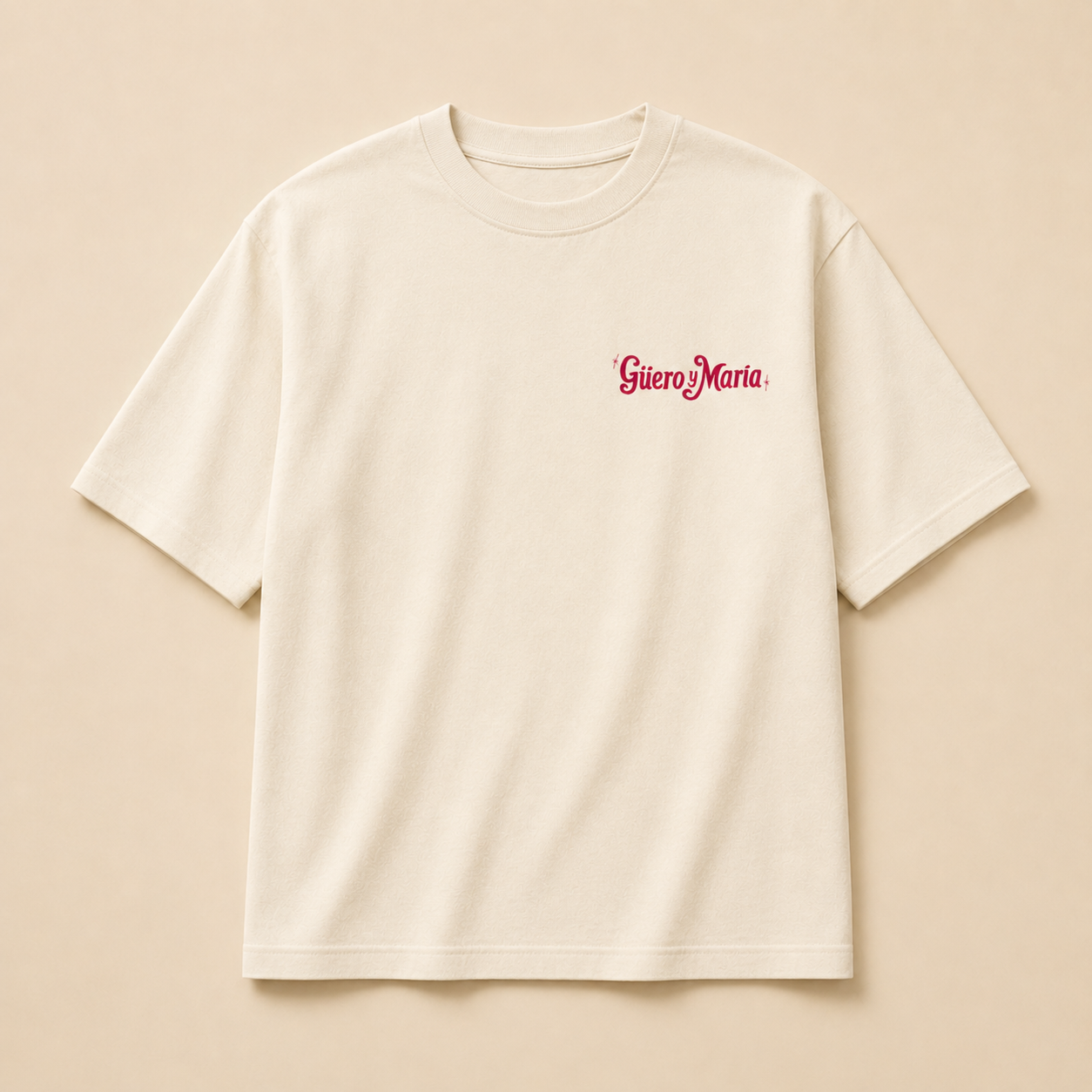 An off-white short-sleeve crewneck t-shirt with "Guero y Maria"  log in red cursive on the left chest, displayed flat against a matching warm beige background.